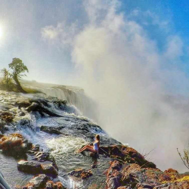 Female traveler posing for travel photography at Victoria Falls