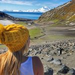 Adventure traveler being in the moment while watching penguins in Antarctica.