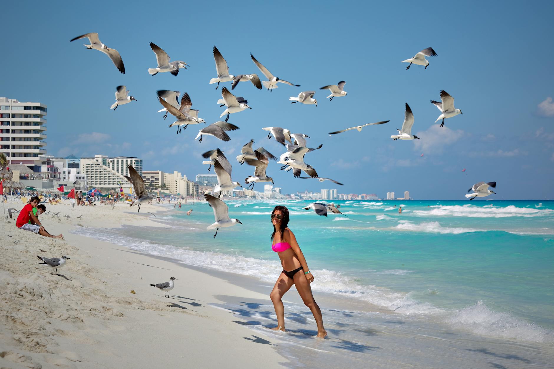 photo of a woman under flying seagulls in Cancun mexico