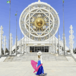 travel blogger Alyssa Ramos @mylifesatravelmovie in front of the ferris wheel in Turkmenistan Ashgabat